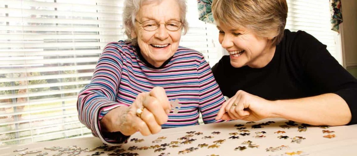 Old Woman and Young Woman Having Fun While Solving a Puzzle